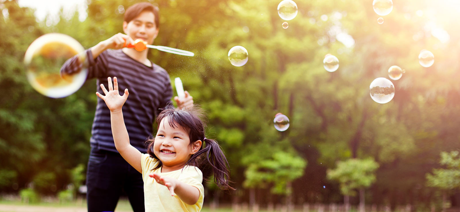 Father and daughter playing with bubbles.