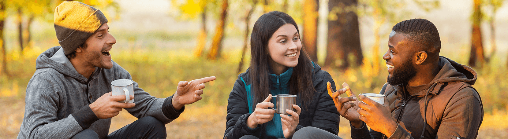 Joyful group of friends enjoying a cup of coffee outdoors