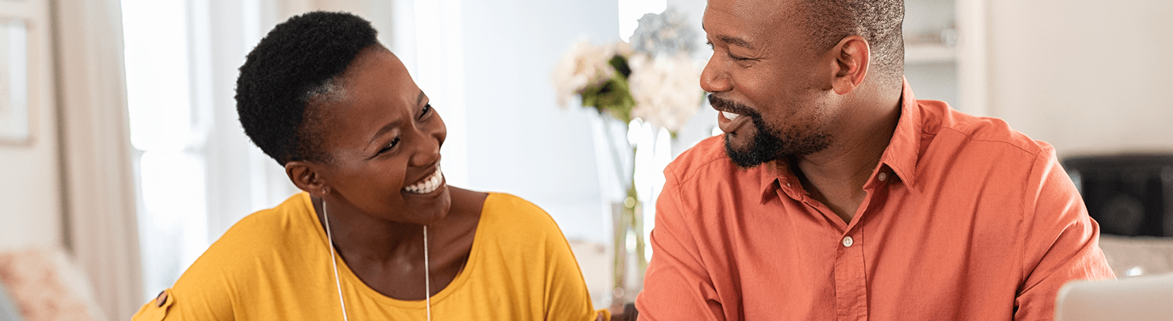 Mature couple at a table in discussion and smiling